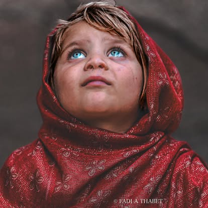 Nei suoi occhi si riflette ciò che resta del cielo quando la terra brucia. Non è solo un bambino di Gaza: è l’intera infanzia del mondo che ancora osa credere nella luce